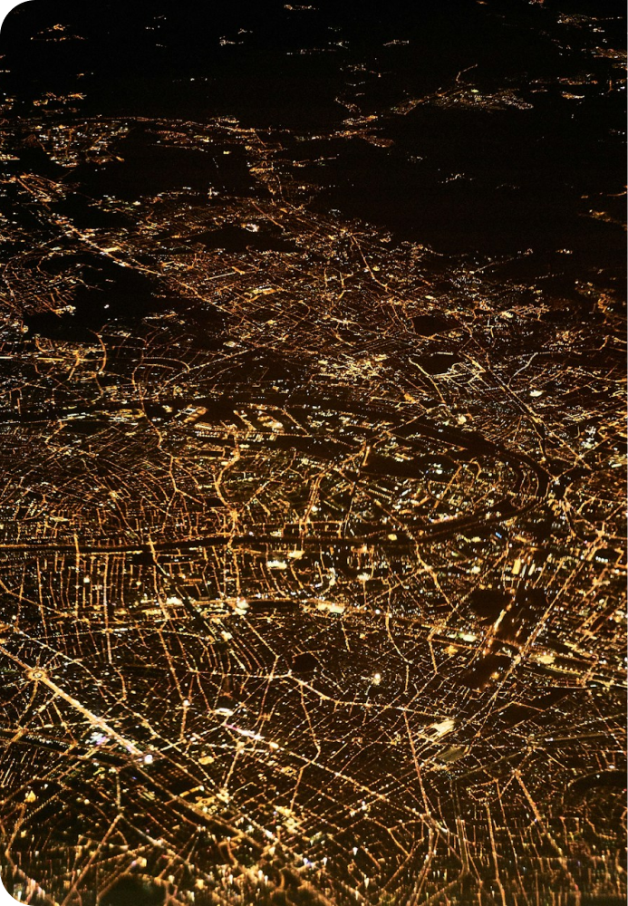 Image of a city lit up at night from an airplane or other jet.