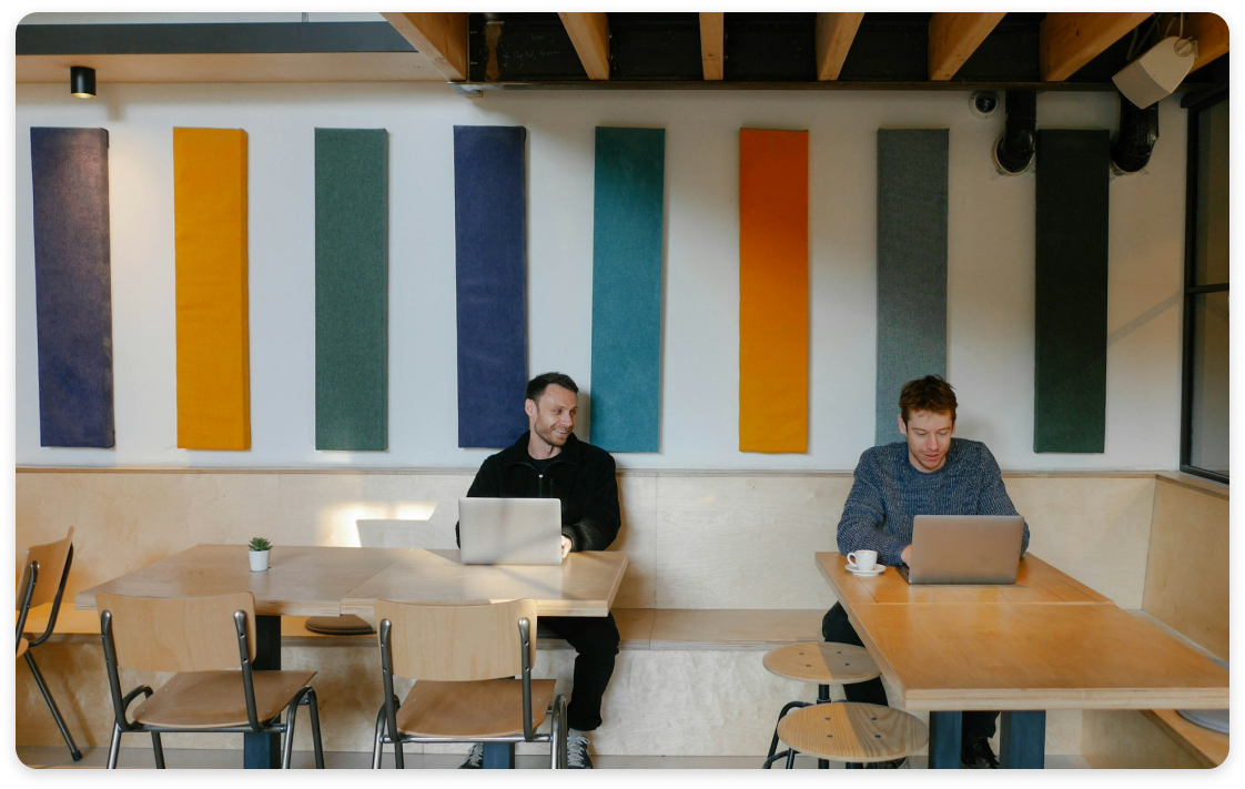 Two people working together and conversing in an office space.